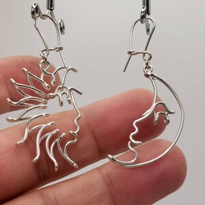 Bijou artisanal unique : boucles d’oreilles Soleil et Lune façonnées en fil doré torsadé, capturant la beauté et l’équilibre du cosmos.