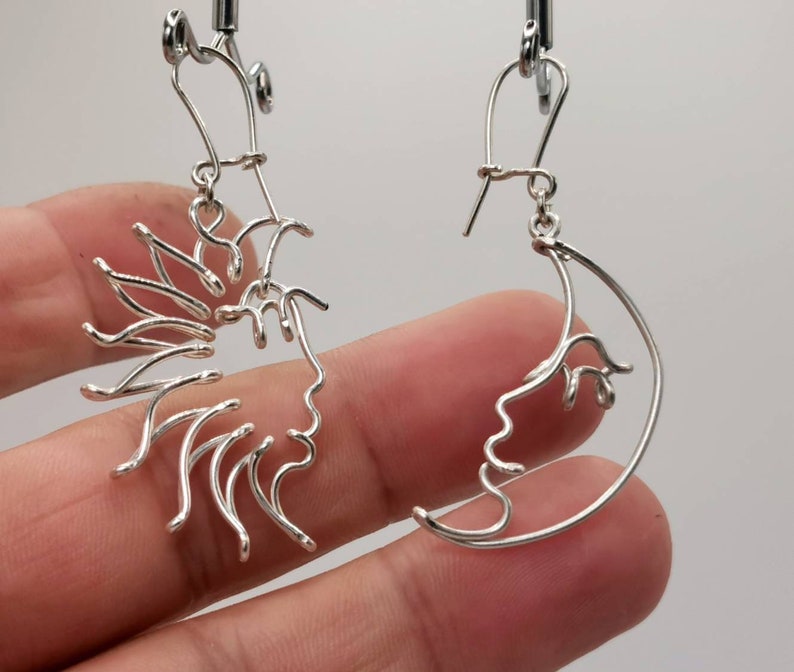 Bijou artisanal unique : boucles d’oreilles Soleil et Lune façonnées en fil doré torsadé, capturant la beauté et l’équilibre du cosmos.