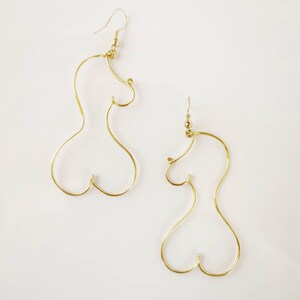 Boucles d’oreilles longues et légères en acier inoxydable doré, inspirées des formes féminines.