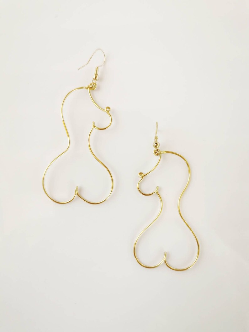 Boucles d’oreilles longues et légères en acier inoxydable doré, inspirées des formes féminines.