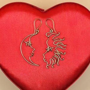 Paire de boucles d’oreilles artisanales représentant le soleil et la lune, fabriquées en fil doré. Un bijou symbolique et original pour les amoureux de l’astronomie et des designs uniques.