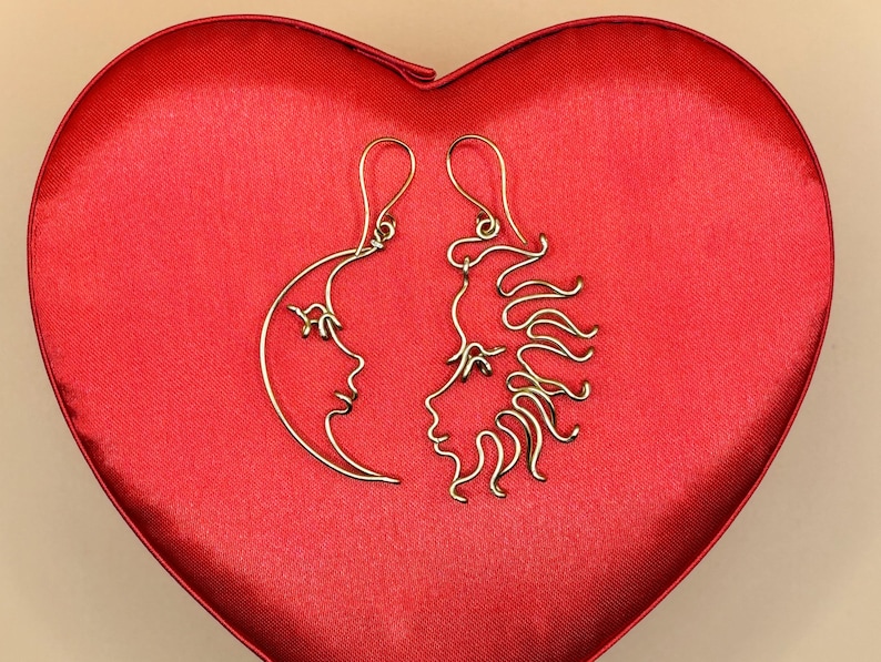 Paire de boucles d’oreilles artisanales représentant le soleil et la lune, fabriquées en fil doré. Un bijou symbolique et original pour les amoureux de l’astronomie et des designs uniques.