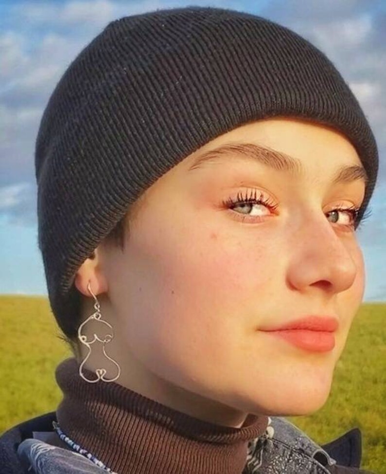 Paire de boucles d’oreilles élégantes et artistiques en fil de métal doré, inspirées de l’anatomie féminine.