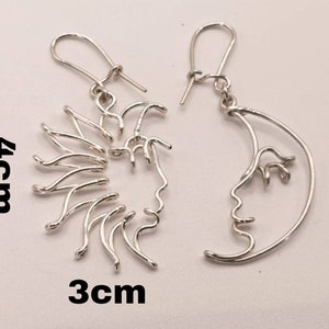 Boucles d’oreilles Soleil et Lune conçues en acier inoxydable doré, photographiées sur fond neutre. Accessoire raffiné et symbolique pour sublimer toute tenue.