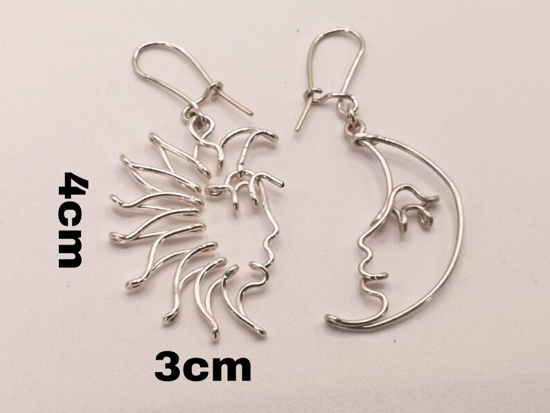 Boucles d’oreilles Soleil et Lune conçues en acier inoxydable doré, photographiées sur fond neutre. Accessoire raffiné et symbolique pour sublimer toute tenue.