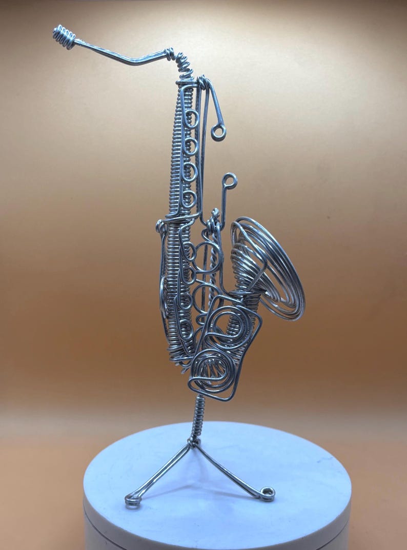 Création artistique représentant un saxophone, en fil métallique, parfaite pour une décoration musicale.