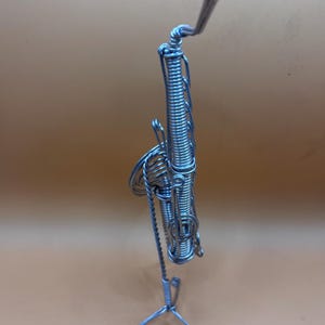 Création artistique représentant un saxophone, en fil aluminium , parfaite pour une décoration musicale.