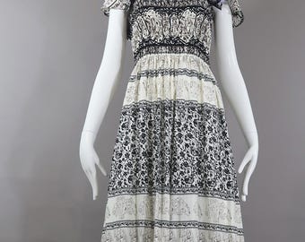 Vestido largo hecho a mano: estampado floral exótico, busto fruncido, bajo con volantes, rayón vaporoso.