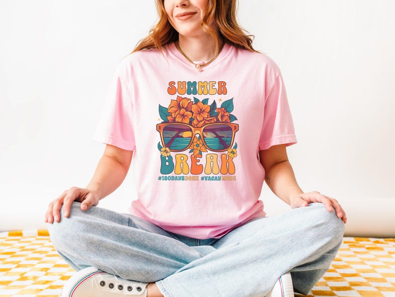 May include: Pink t-shirt with a retro graphic design featuring sunglasses, flowers, and the text "Summer Break" with the hashtags "#180days" and "#vacaymode".