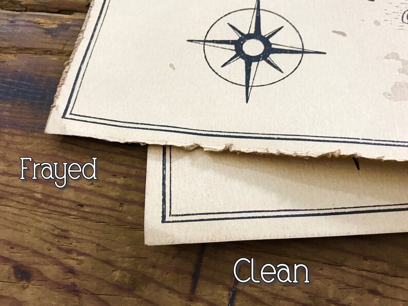 A close up of two maps resting on top of each other to show the corners and the edges. The map on top has frayed edges, while the map below has clean edges. Both are resting on a brown wooden surface.