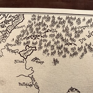 A close up of the details of the map, including the ocean, trees, and mountains.