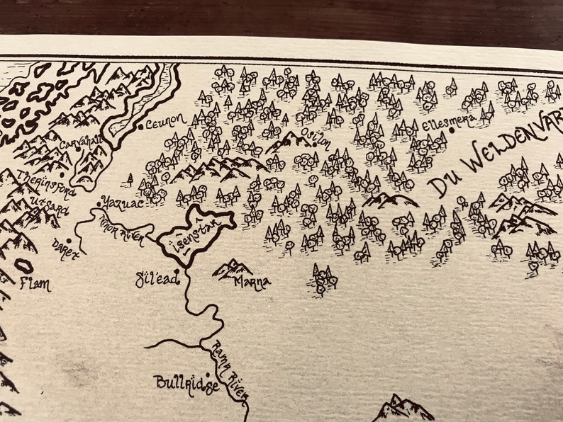 A close up of the details of the map, including the ocean, trees, and mountains.