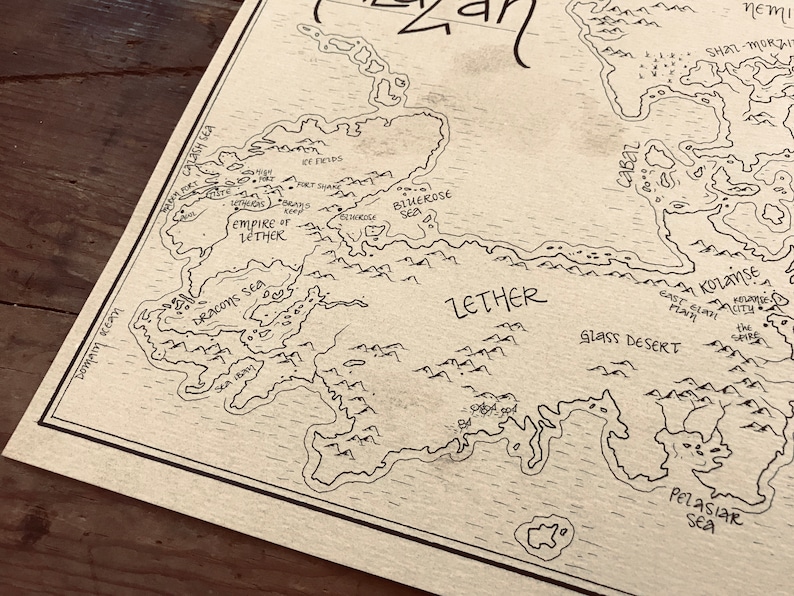 A close up of the details of the map, including the ocean, trees, and mountains.
