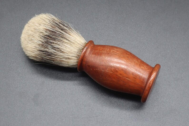 Eucalyptus shaving badger hair brush over a dark background