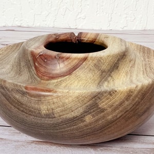 Camphor wood bowl - close-up showing curved grain pattern and multiple colors, including the red-brown knot at the top of the bowl