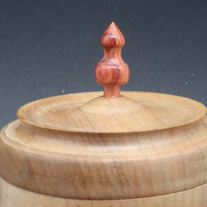 Close-up of wooden bowl made of maple and tulipwood with lid to show handle on lid.