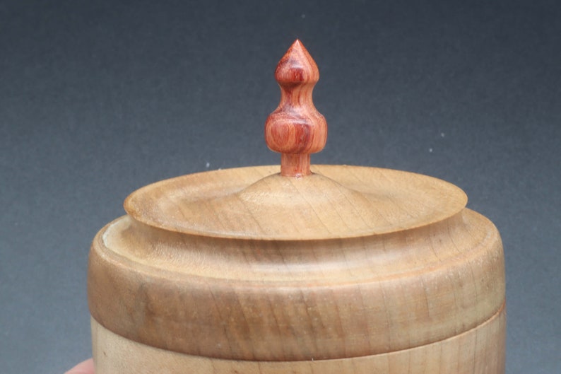 Close-up of wooden bowl made of maple and tulipwood with lid to show handle on lid.