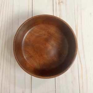 Indian Rosewood wooden bowl on woodgrain table - top down view showing inside of the bowl and the grain pattern