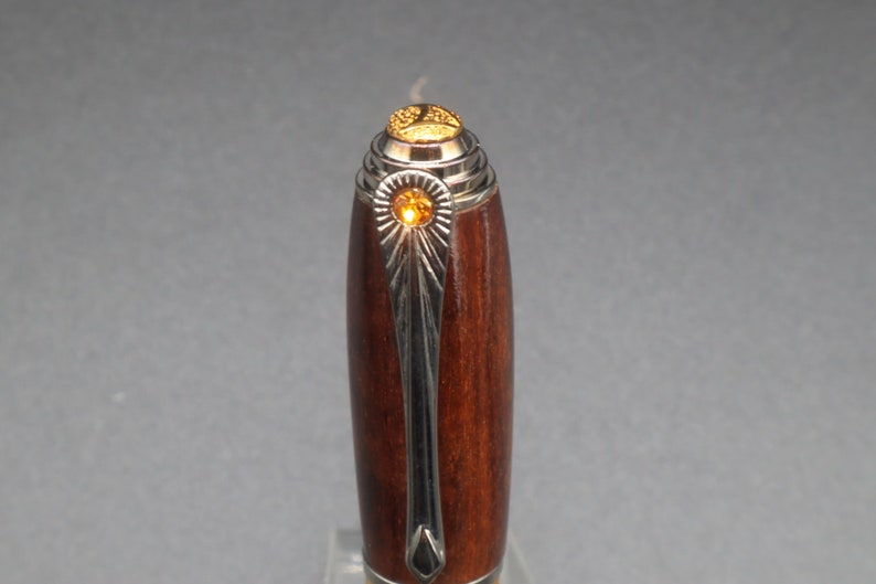 Close-up view of top of fountain pen made of ringed gidgee wood - to show off gold art deco detailing and crystal.