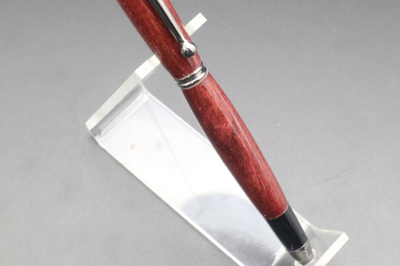 View of pen barrel for Purpleheart stylus pen with gun metal hard in clear pen stand over black background