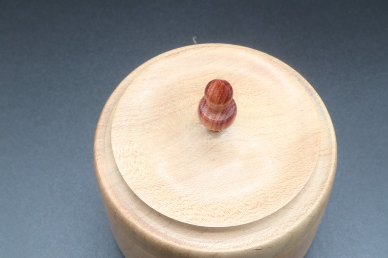 Top of wooden bowl made of maple and tulipwood with lid.