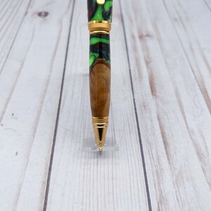 Close up view of pen tip of olive wood and resin twist pen with satin gold hardware