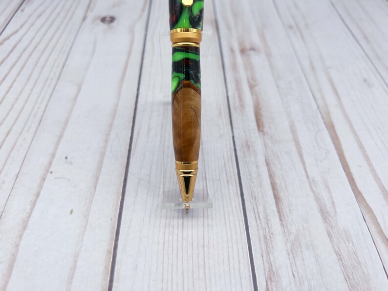 Close up view of pen tip of olive wood and resin twist pen with satin gold hardware