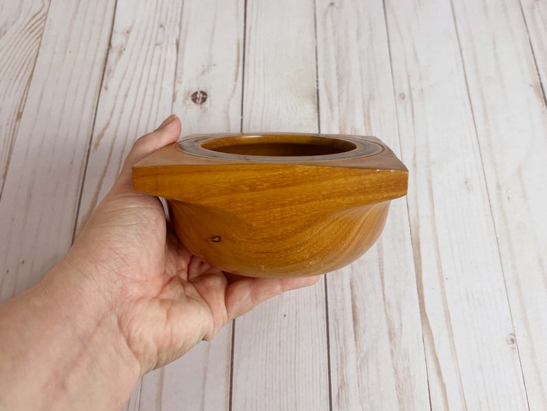 Osage Orange wooden bowl with square top and round opening and bowl - bowl being held so you can see the side with the square top and round bottom