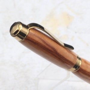 Close-up of top of Titanium Gold Cigar Pen made with olive wood and gold hardware