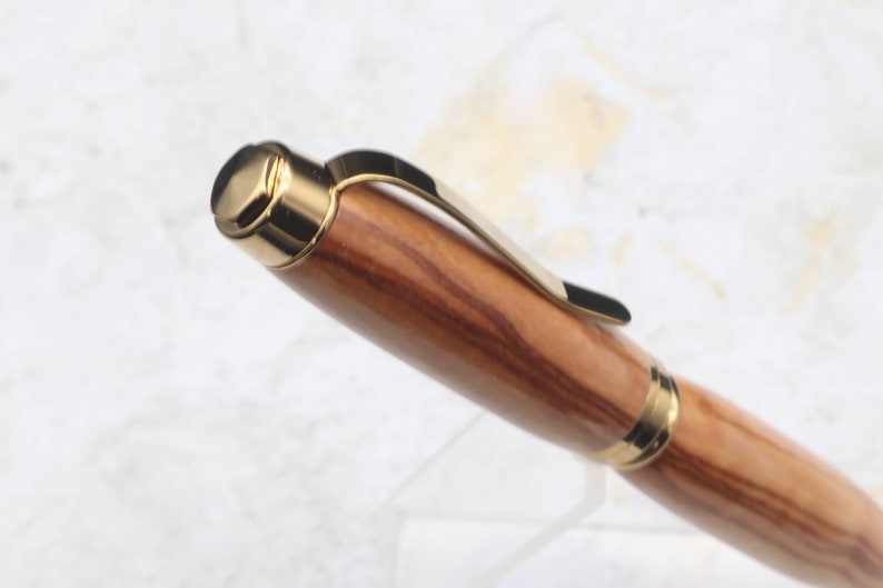 Close-up of top of Titanium Gold Cigar Pen made with olive wood and gold hardware