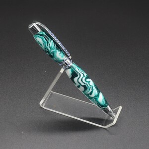 Full side view of green and white (aka seafoam green) princess pen with blue crystals and chrome hardware on clear pen stand.