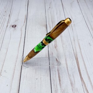 Side view of olive wood and resin twist pen with satin gold hardware