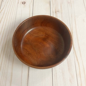 Indian Rosewood wooden bowl on woodgrain table - top down view to show wood grain and inside of the bowl