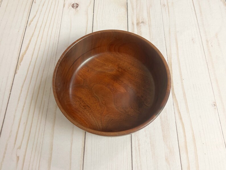 Indian Rosewood wooden bowl on woodgrain table - top down view to show wood grain and inside of the bowl