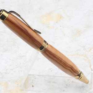 Side view in clear pen stand of Titanium Gold Cigar Pen made with olive wood and gold hardware