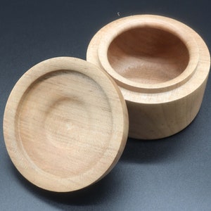 Wooden bowl made of maple and tulipwood with lid. Lid is upside down to see the underside of the lid.