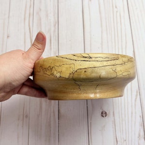 Camphor bowl with wide opening and narrower base - side view, showing grain pattern of wooden bowl while being held