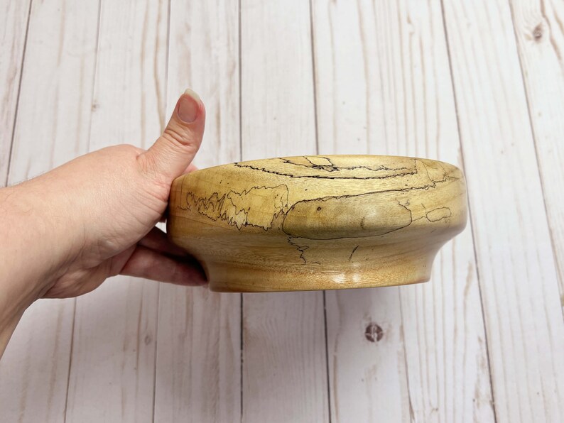 Camphor bowl with wide opening and narrower base - side view, showing grain pattern of wooden bowl while being held