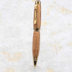Front view in clear pen stand of Titanium Gold Cigar Pen made with olive wood and gold hardware