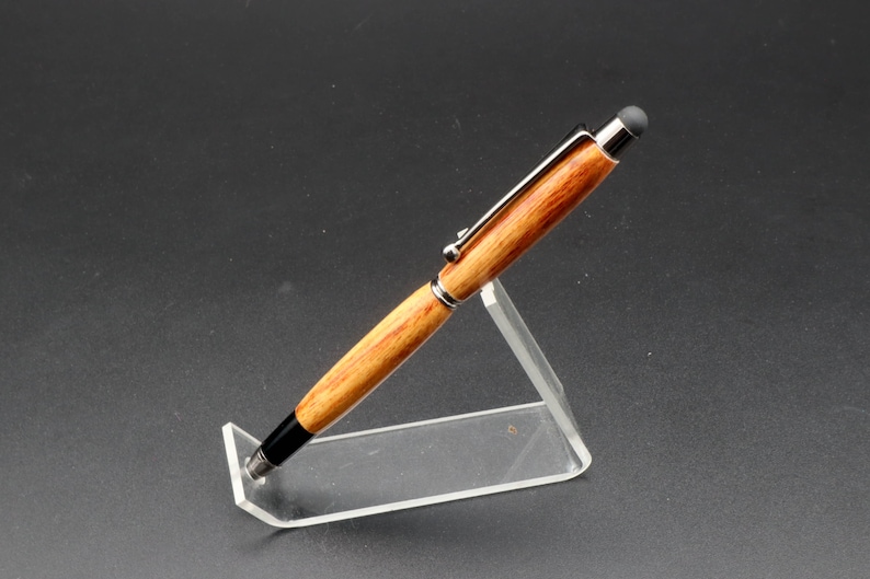 Side view of Canarywood stylus pen with gun metal hardware in pen stand over black background