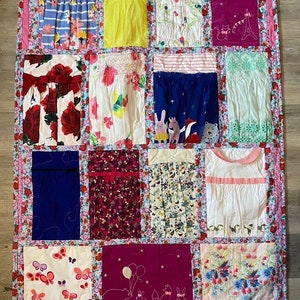 May include: A patchwork quilt with a variety of floral and animal prints. The quilt is made up of 12 squares, each with a different design. The quilt is pink, blue, white, red, and yellow.