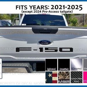 May include: A white ceramic mug with a black handle and the text "But First, Coffee" in a bold, black font. The mug is set against a blurred background, suggesting a cozy setting.