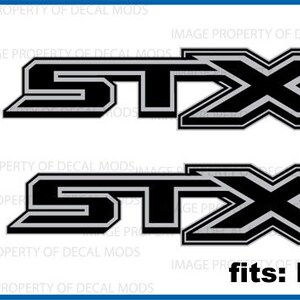 May include: Two black and silver Ford STX decals with a gray outline. The decals are for a Ford F150 truck.