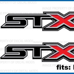 May include: A pair of black and silver decals with a red "X" for a Ford F150 truck. The decals say "STX" and are officially licensed Ford products.