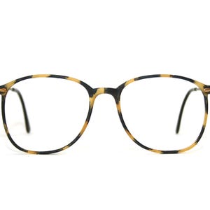 Könnte beinhalten: Schildpatt-Brille mit runden Gläsern und schwarzen Bügeln.