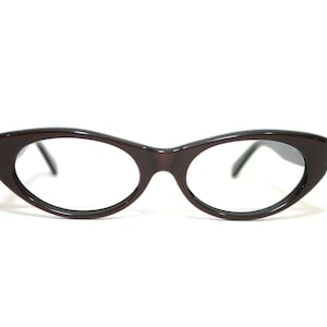 May include: A pair of brown cat-eye glasses with clear lenses.