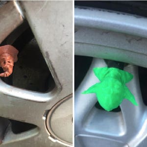 May include: Two different car tire valve stem caps. One is a brown, 3D printed figure of a wizard wearing a pointed hat. The other is a green, 3D printed figure of a creature with wings.