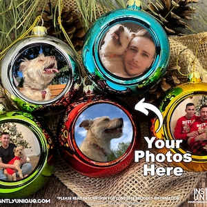 Op de afbeelding: Vier ronde, metalen kerstballen in groen, rood, taling en goud, elk met een ronde foto-inzet. De ballen tonen verschillende afbeeldingen van mensen en honden. De tekst rechts luidt Your Photos Here, met een witte pijl die ernaar wijst.