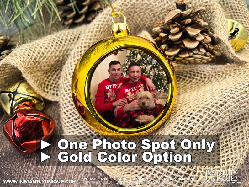 Op de afbeelding: Een ronde gouden kerstbal met een centrale ronde foto van twee personen in rode truien met een kleine hond. De kerstbal heeft een gouden dop en een ophanglus. De tekst op de afbeelding luidt: One Photo Spot Only, Gold Color Option.