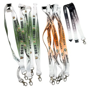 May include: A collection of colorful lanyards with various designs and text. Some lanyards feature a green and white design with the text "SHSS" repeated, while others have an orange and white design with the text "UNIVERSAL ORLANDO 2024".